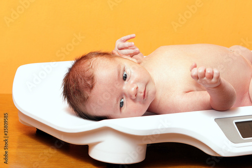 Photo: baby boy on weight scale baby boy on weight scale