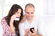 Foto: Young couple doing online shopping with smartphone Young couple doing online shopping with smartphone
