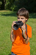 boy taking shots with photocamera in park