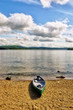 Green canoe on lake shore