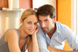Happy young couple standing in home kitchen Happy young couple standing in home kitchen