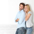 Young couple standing on white wall