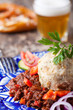 Gulasch mit Knödel auf einem blauen Teller Gulasch mit Knödel auf einem blauen Teller