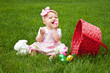 Baby Smiling while holding an Easter egg beside basket