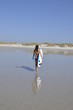jeune fille avec son surf rentant sur la plage