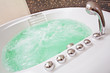 Jacuzzi with swirling water and brown mosaic in bathroom