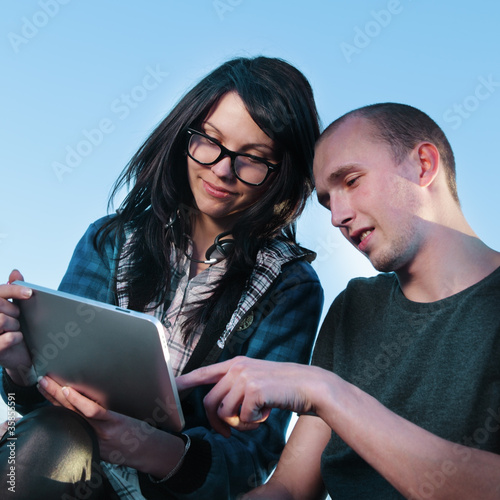 Photo: beauty girl and boy with tablet pc outdoors beauty girl and boy with tablet pc outdoors