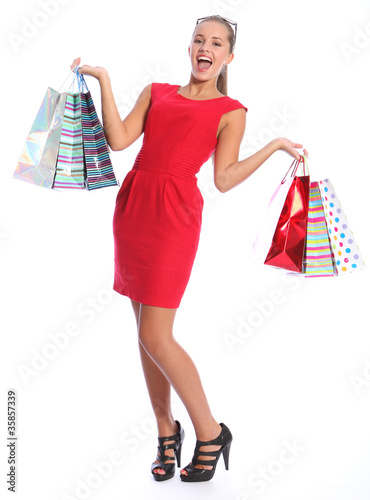 Photo: Sexy happy woman in red dress shopping gift bags Sexy happy woman in red dress shopping gift bags
