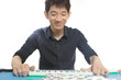 Chinese man play Mahjong, traditional China gamble.