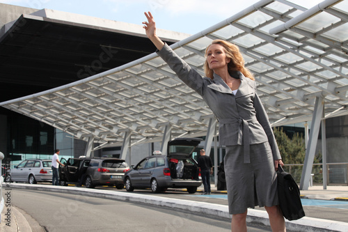 Photo: Businesswoman waving taxi Businesswoman waving taxi
