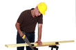 Photos : Tradesman sawing a piece of wood
