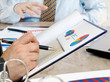 hands with financial charts at business meeting in the office. hands with financial charts at business meeting in the office.
