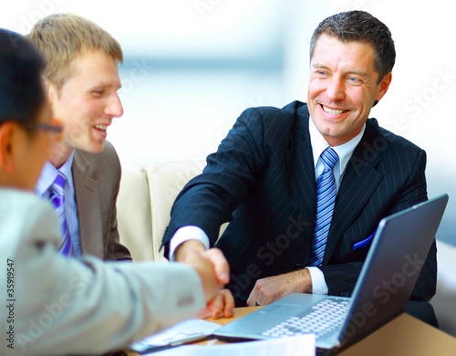 Photo: Business people shaking hands, finishing up a Business people shaking hands, finishing up a