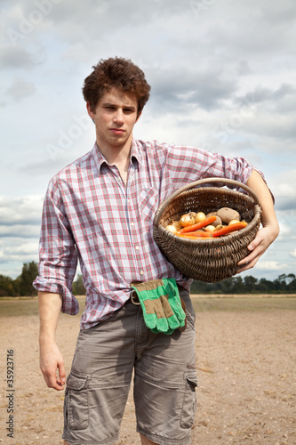 Photo: young agriculturist on the cultivated field young agriculturist on the cultivated field