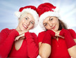 Pretty girls with santa hat has fun in front of blue sky