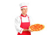 A studio shot of a young chef holding a pizza A studio shot of a young chef holding a pizza