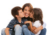 Son and daughter kissing mother on a white background