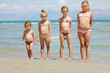 children with sun lotion on the beach