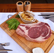 Côte de boeuf crue sur une planche en bois