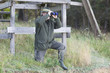 Jäger mit Fernglas vor Hochsitz