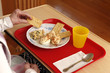 Tray with lunch and old person hands