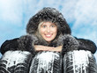 Foto: Beautiful woman with winter coat behind snowy winter tyres Beautiful woman with winter coat behind snowy winter tyres