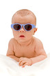Funny baby in sunglasses  lying on the blanket - isolated