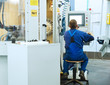 Foto: worker operating CNC machine center worker operating CNC machine center