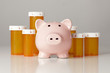 Foto: Piggy Bank In Front of Several Medicine Bottles Piggy Bank In Front of Several Medicine Bottles
