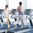Young woman and man at the gym exercising. Running Young woman and man at the gym exercising. Running