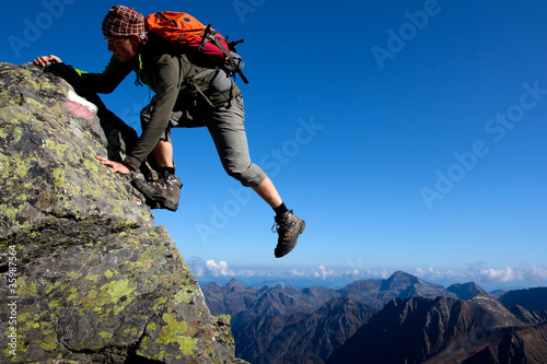 Photo: Young man climbing the mountain ridge Young man climbing the mountain ridge