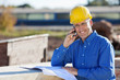 handwerker telefoniert auf der baustelle