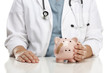 Doctor Holding Caring Hand on a Piggy Bank with Bandage Doctor Holding Caring Hand on a Piggy Bank with Bandage