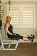 Attractive blond woman using exercise machine