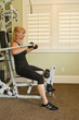 Attractive blond woman using exercise machine