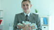 Businessman holding a heap of dollar bills in office