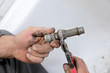 Plumber hands fixing water pipe with spanner Plumber hands fixing water pipe with spanner