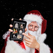 Photo : Santa Claus placing orders on his tablet-pc