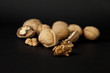 Cracked and whole walnuts in black background