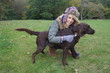 Pretty girl playing with her dog in the garden