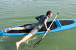 Paddler liegt auf dem Board