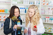 apothekerin und kunden schauen auf rezept