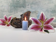 Stilleben mit Lilienblüten und Kerze