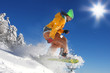 Snowboarder jumping against blue sky