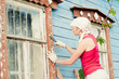 Young woman making cosmetic alterations of house