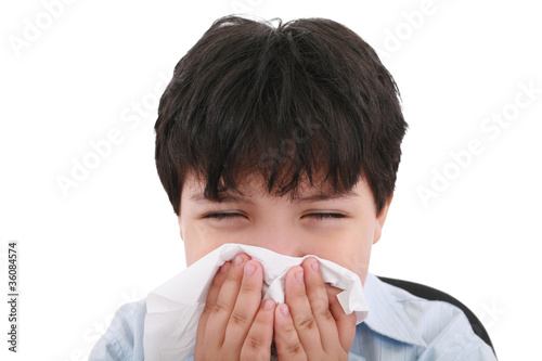 Photo: sick boy blowing his nose, white background sick boy blowing his nose, white background
