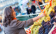 Beutiful woman buying grapes at market
