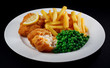 Close up of fish and chips with peas and a slice of lemon. Close up of fish and chips with peas and a slice of lemon.