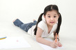 Little Asian girl drawing, lying on floo