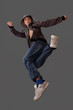 Foto: boy in a jump simulates a dance element on a gray background boy in a jump simulates a dance element on a gray background